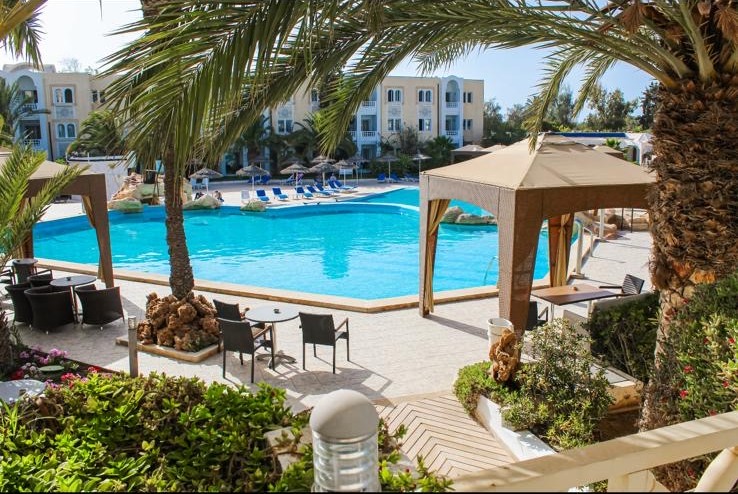 Piscine et jardins du Joya Paradise sous le ciel bleu de Djerba